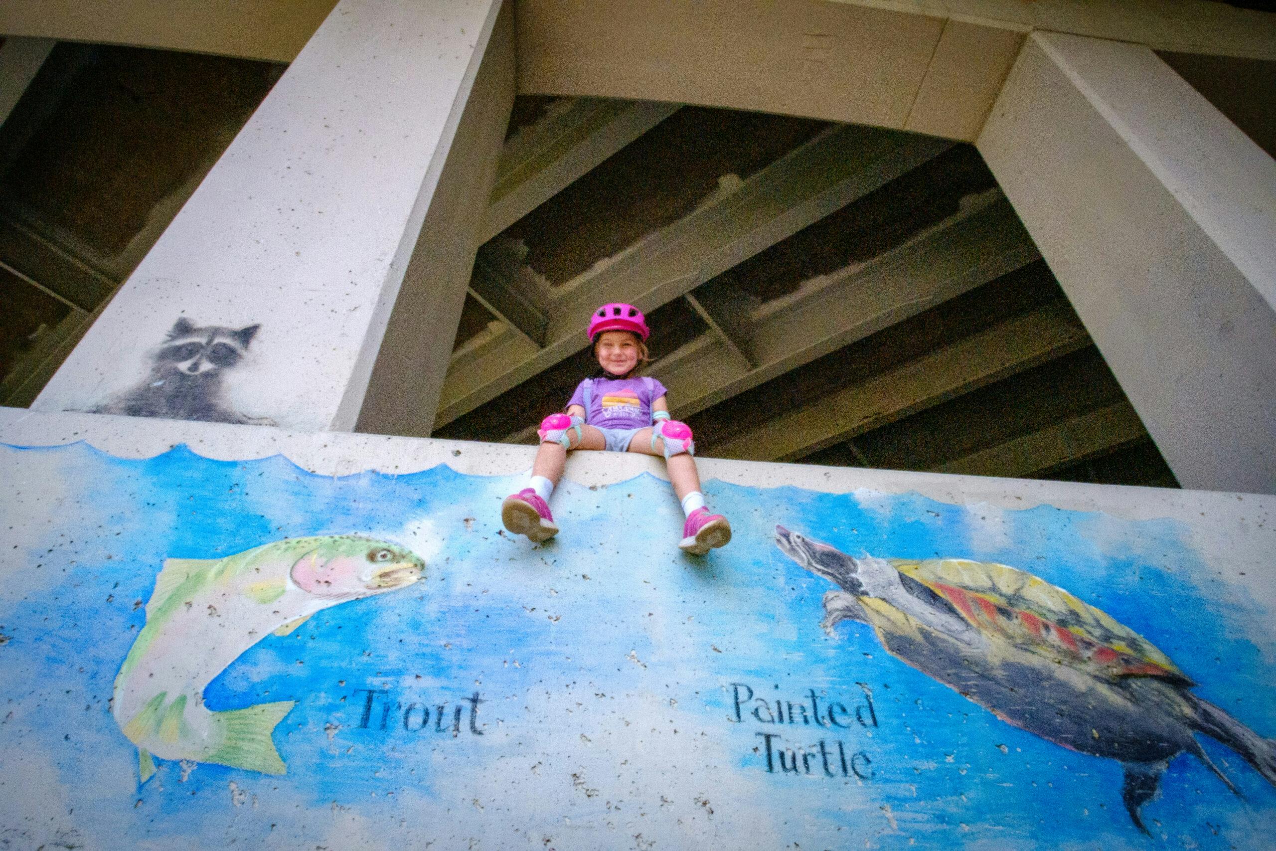 Kid under an overpass with chalk art